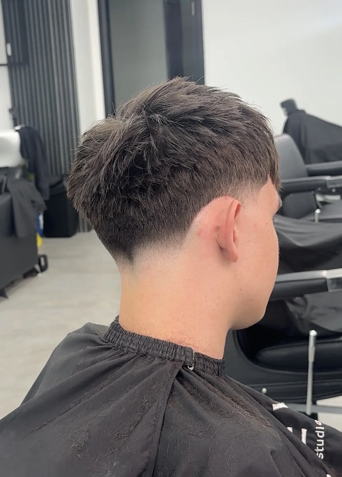 Studio Eleven barbershop haircut — textured crop with clean fade